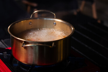 Northeastern-style soup called Jaew Hon in a brass pot on a picnic stove.