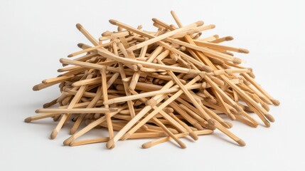 Heap of wooden matchsticks scattered on a clean white background showcasing their natural texture and color for various creative uses
