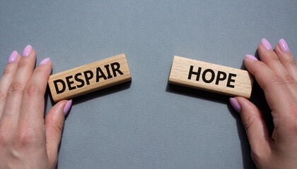 Despair or Hope symbol. Concept word Despair or Hope on wooden blocks. Businessman hand. Beautiful grey background. Business and Despair or Hope concept. Copy space