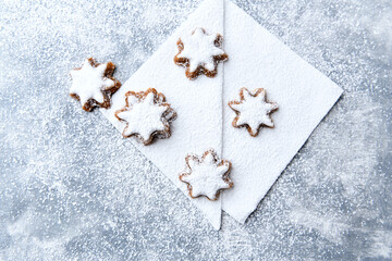 Christmas cookies (cinnamon stars) on bright wooden background. Top view.