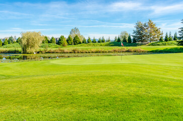 Golf course with gorgeous green and pond.