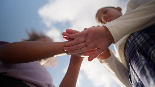 Multiethnic schoolgirls students pupils two little girls sisters happy children kids African American classmates education class studying teamwork unity putting hands stack together play game outdoors