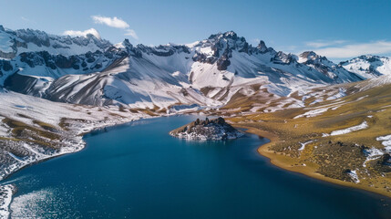 Fototapeta premium An aerial panoramic view of the snowing mountains and a lake