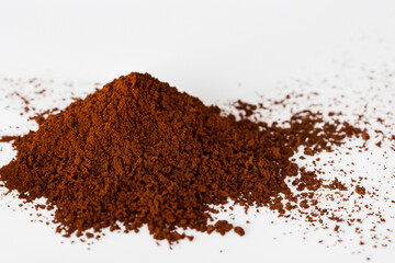 Pile of brown powder on surface. White coffee with powder on white background. Handful of coffee and a handful of powder lying on a white background. A handful of coffee powder lies on a lifestyle.