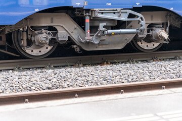 Closeup of a pivoted bogie of a train on the tracks. Blank steel area of brakes, damper and other...