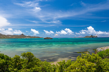 View across the turquoise lagoon and reefs of Carriacou's Manchineel Bay to Belmont and Dumfries with White Island and Saline Island on the horizon 
