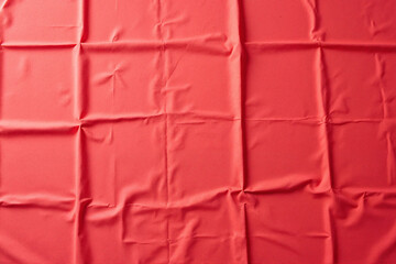 Textured bright red fabric with folds for backgrounds and textile design
