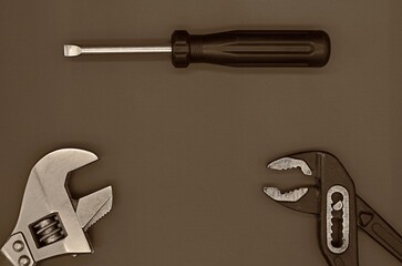 screwdriver, adjustable wrench and gas wrench on a dark background