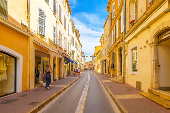 Fototapeta A colorful street of shops in the historic medieval old town district of the seaside city of Saint-Tropez France, along the Cote d'Azur French Riviera Mediterranean.