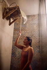 Happy woman taking shower after sauna at wellness spa.