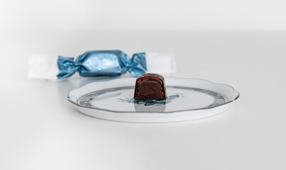 A halved dark chocolate bonbon called szaloncukor on a traditional Herend porcelain plate. 