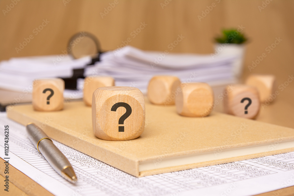Aufkleber engaging in the exploration of uncertainty by utilizing question blocks on a desk surface