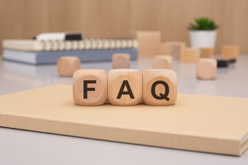 Wooden Blocks Artfully Displaying the FAQ Concept Amidst Various Office Supplies Available