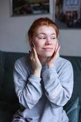 Girl caring of her beautiful skin on the face. Applying moisturizer on her face at home.