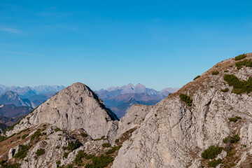Summit of mount Due Pizzi Cima Alta surrounded by rugged mountain peaks of Carnic and Julian Alps. Hiking trail to mount Piper in Friuli Venezia Giulia, Italy. Wanderlust Italian Alps on blue sky day