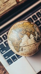 Globe on Laptop Keyboard Representing Global Connectivity and Digital World Exploration