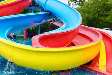 Colorful slide in a water park. Tourist attraction with water slides in the park. Tourist attraction with colorful water. A slide and a water attraction in lifestyle a park.