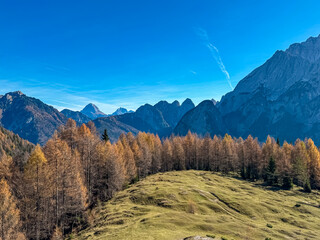 Scenic hiking path through alpine meadow with view of majestic mountains peaks Julian Alps in...