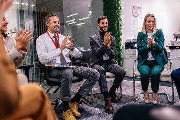 Group of multiracial business people on an group psychotherapy conference, seminar in their office applauding.