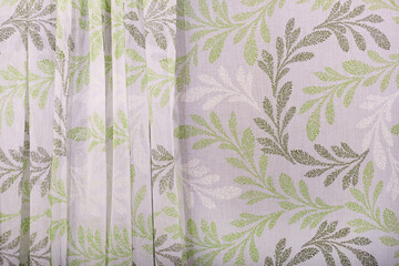 A patterned curtain. The folds of the waves of tulle are thin.