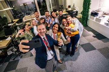 Business people taking a selfie after an annual award ceremony in the office.