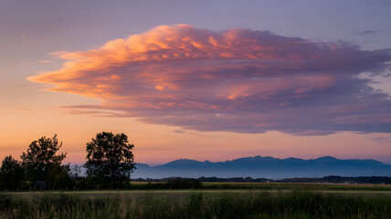 Obraz premium A serene evening sky with layered clouds painted in shades of orange and purple