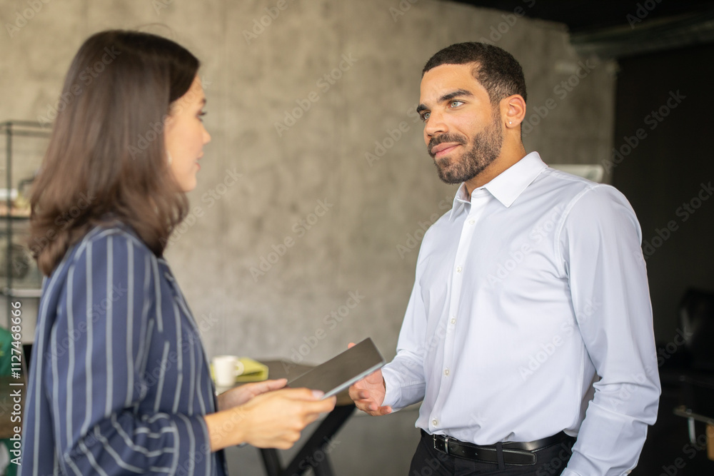 Poster two professionals engage in a productive discussion at a modern office. they exchange ideas and mate