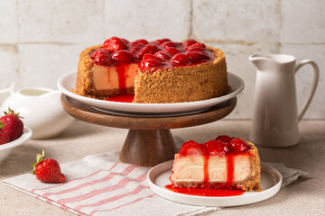 Breakfast with classic baked cheesecake  with a strawberry topping sauce. Homemade dessert on a beige table surface.