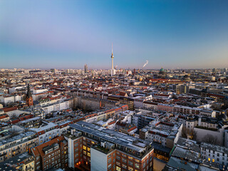 Aerial view of Berlin mitte district showing rooftops, landmarks like Fernsehturm TV tower and Berliner Dom Cathedral at dusk with purple and blue sky