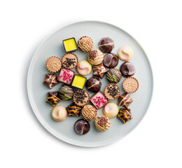 Mix of chocolate pralines on plate isolated on white background.