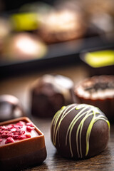 Mix of chocolate pralines on wooden table.