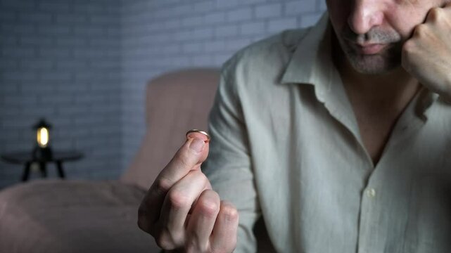 Husband complaining after divorce. A view of sad man complain after divorce with golden ring indoor.