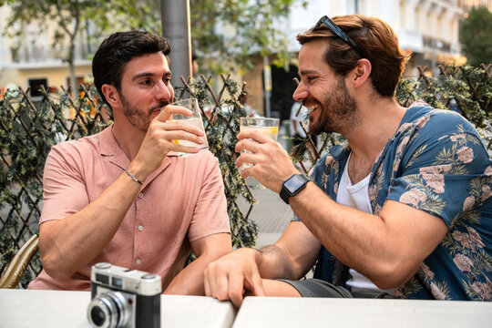 Gay couple enjoying drinks at an outdoor cafe