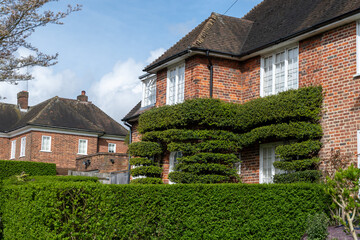 Walking on streets of North London, red brick houses and flowering gardens in spring, city life, wealthy neighbourhoods in London, UK