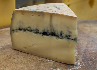 French semi-soft cow milk cheese morbier from Franche-Comte region with thin black layer and strong aroma