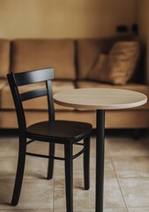 Fototapeta premium A black chair sits in front of a wooden table