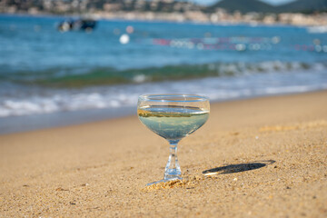 Summer time on French Riviera, two coupe glasses of champagne cremant sparkling wine on Pampelonne sandy beach near Saint-Tropez in sunny day, Var, vacation in France