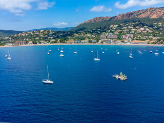 Obraz premium Panoramic view from above on blue Mediterranean dea, sandy beach of Agay town, summer vacation destination near Esterel mountains, French Riviera, Provence. France