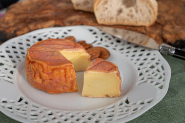 Rond des Vignes washed-rind cheese with.ivory-orange rind, strong nose with aromas, French soft cheese with orange rind