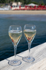 Summer time in Provence, two glasses of cold champagne cremant sparkling wine on famous Pampelonne sandy beach near Saint-Tropez in sunny day, Var department, France, beach club party
