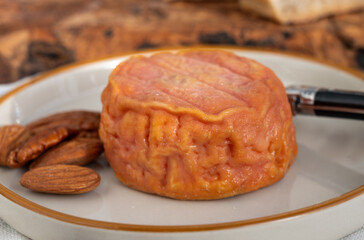 Rond des Vignes washed-rind cheese with.ivory-orange rind, strong nose with aromas, French soft cheese with orange rind