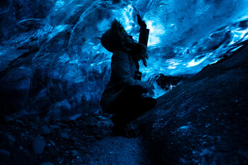 Young woman's silhouette in ice cave in Iceland in winter