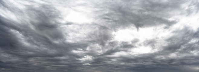 Panorama of gray cloud filled rain sky with local transparent areas
