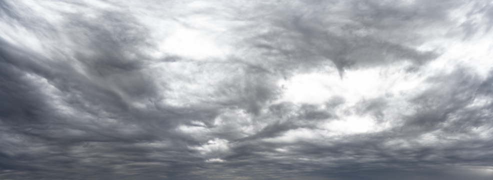 Panorama of gray cloud filled rain sky with local transparent areas
