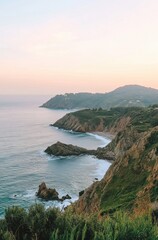 Fototapeta premium A beautiful ocean view with a rocky shoreline and mountains in the background