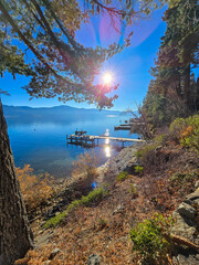 a gorgeous winter landscape at Lake Tahoe with blue lake water, lush green trees and plants,...