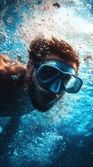 Naklejka premium A diver's silhouette descending into the blue ocean depths among fish and corals illuminated by sunbeams