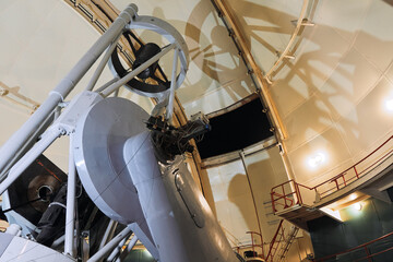 Large telescope illuminated by a bright light in an observatory setting