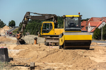 Excavator and Road Roller at a Construction Site