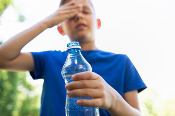 Child drinking water in the heat of the day, dealing with summer heat wave 